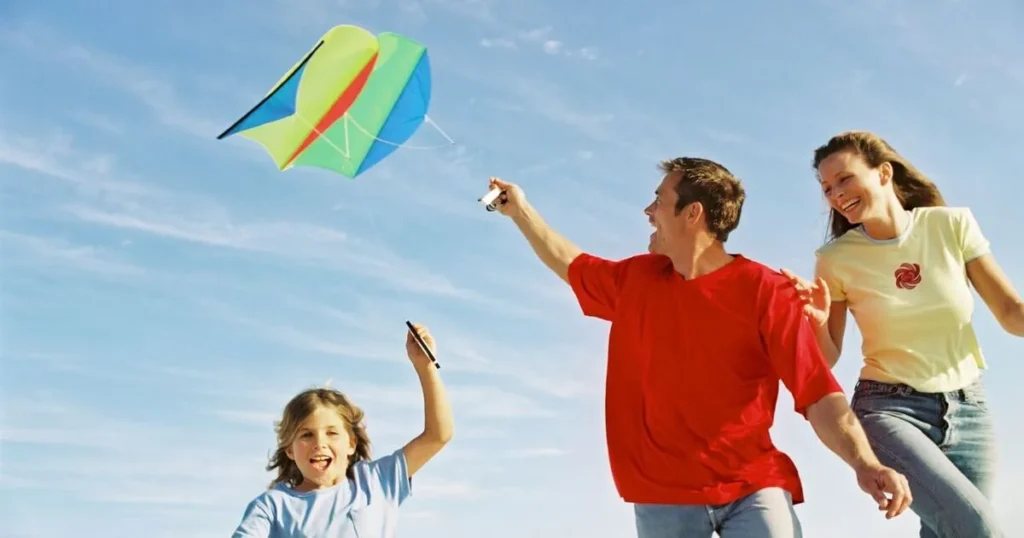 Man is flying a kite with his family