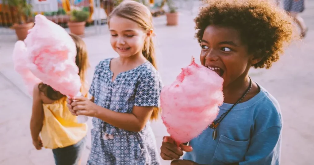 Kids eating cotton candy at amusement park