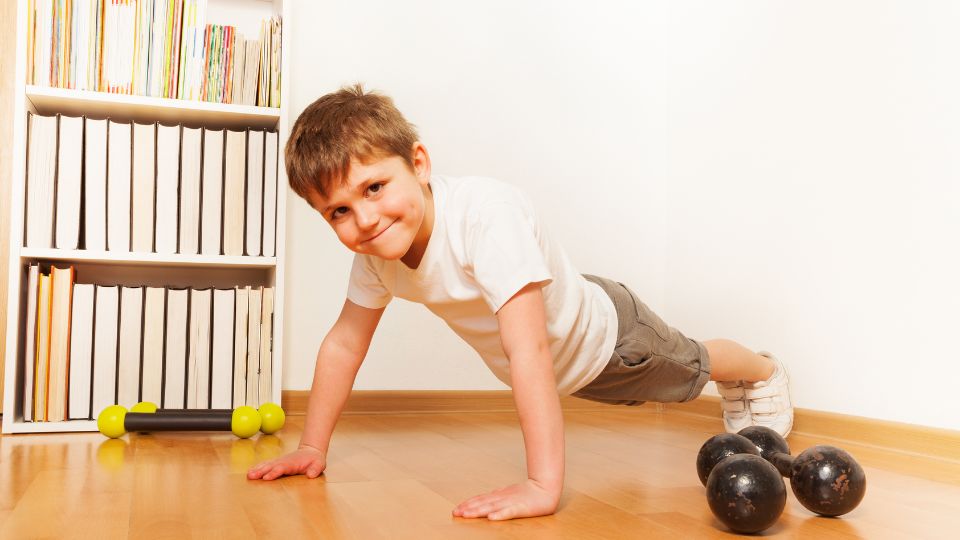 A boy doing pushups in his home